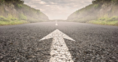 A road with a white arrow pointing forward.