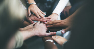 A group of hands joined in solidarity and support