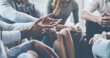 A group of people in a circle as part of a support group