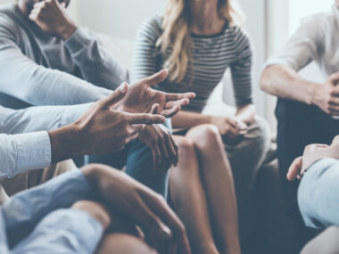 A group of people in a circle as part of a support group