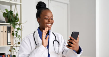 A female doctor greeting a patient on a cell phone call