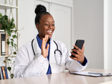 A female doctor greeting a patient on a cell phone call