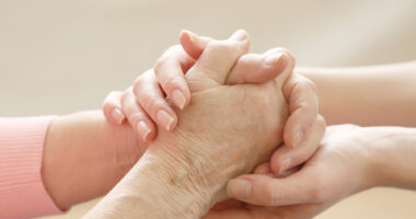 close-up of two people holding hands to illustrate helping hands