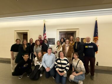 A group of advocates gather for a photo in front of a U.S. representative's office on Capitol Hill.